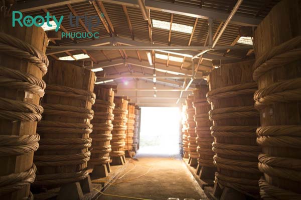 The photo captures large barrels of fish sauce inside Phu Quoc Fish Sauce House 